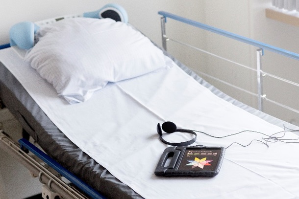 Hospitalsseng med blå højtaler over puden